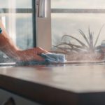 Persona utilizando agua ozonizada para limpiar la encimera de una cocina sin productos químicos