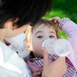 Un bebé tomando agua de un biberón