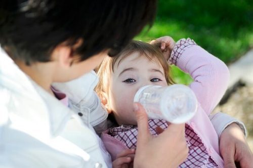 Un bebé tomando agua de un biberón