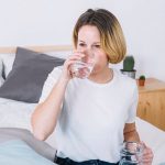 Mujer bebiendo agua de mineralización baja saludable para su riñón